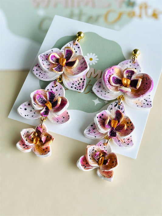 Handmade orchid floral earrings are designed to mirror the natural elegance of orchids, known for their symmetrical and vibrant blooms. Artisans meticulously shape and colour each petal, often drawing inspiration from real orchid species.